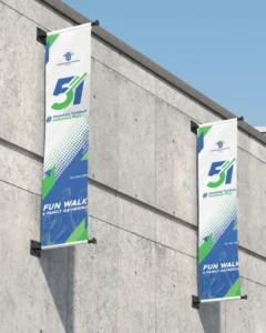 Flag Printing Dubai – Custom outdoor promotional flags mounted on a concrete wall, featuring vibrant event branding and professional-quality flag printing for corporate marketing and advertising campaigns in Dubai